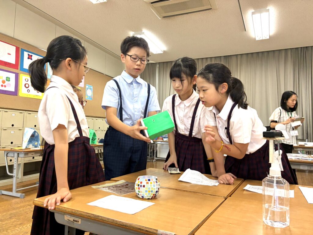 9月の夏休み作品展にて作品に興味を示す児童