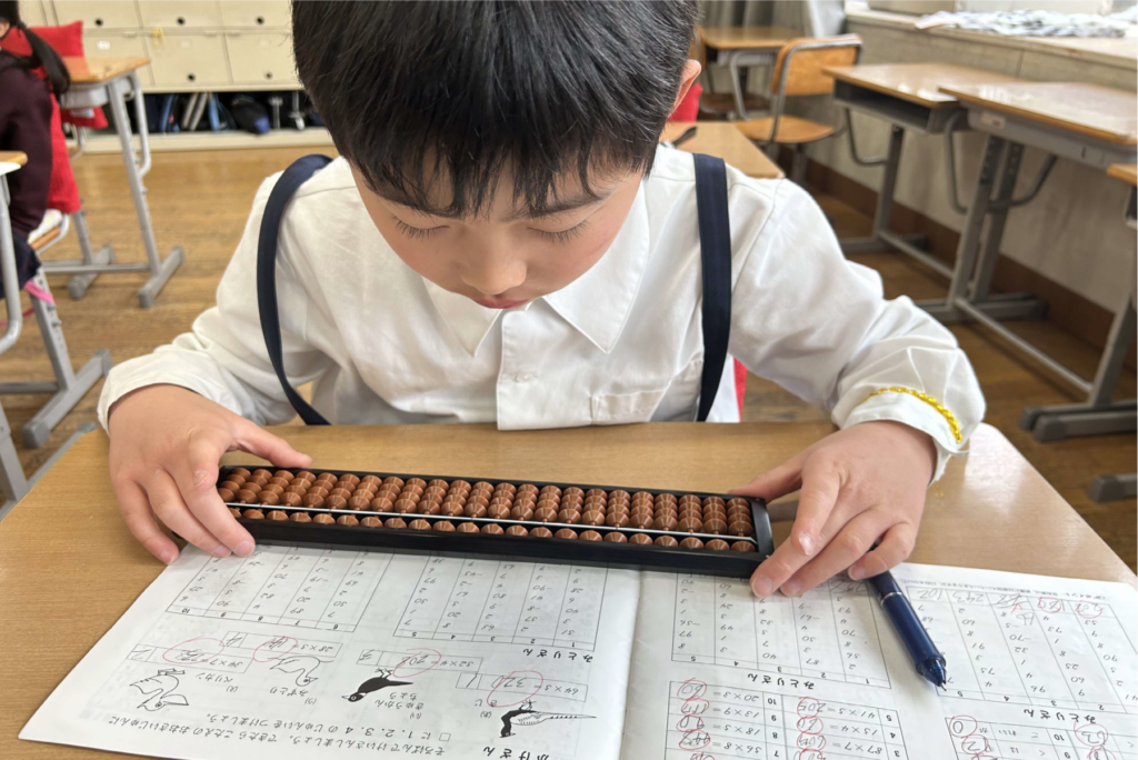 キッズアフターカレッジにてそろばんを練習する児童