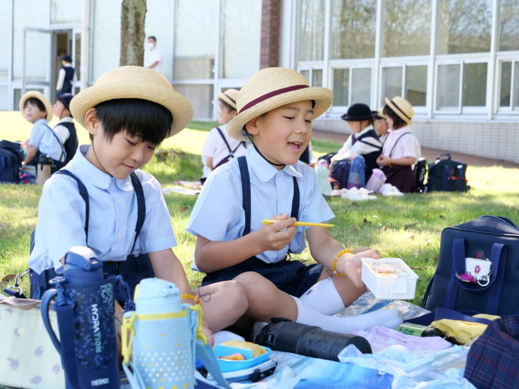憩いの広場にて弁当を食べる児童